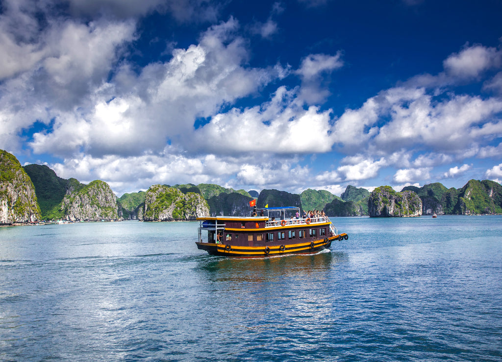 cruising among beautiful limestone rocks and secluded beaches in Ha Long bay, UNESCO world heritage site, Vietnam