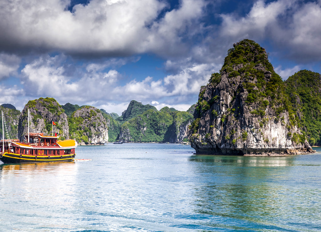 cruising among beautiful limestone rocks and secluded beaches in Ha Long bay, UNESCO world heritage site, Vietnam