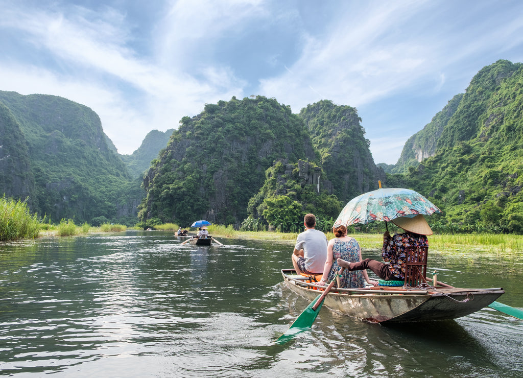 Activity downstream in mountain valley on boat with vietnamese using foot paddle