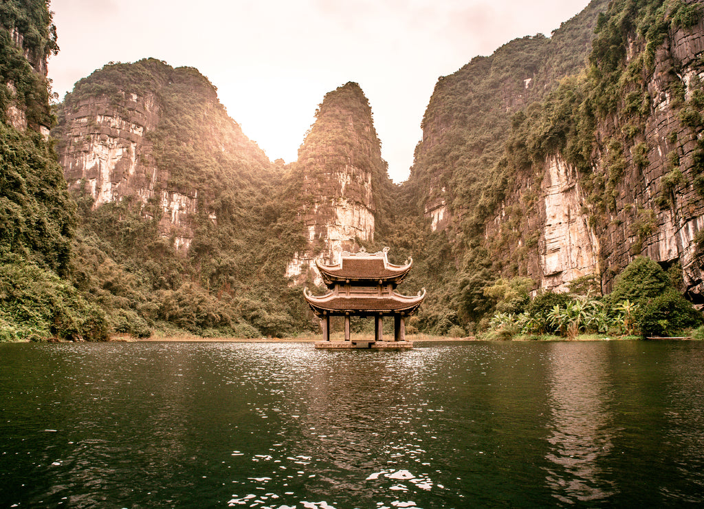Boat cave tour in Trang An Scenic Landscape formed by karst towers and plants along the river (UNESCO World Heritage Site). It's Halong Bay on land of Vietnam. Ninh Binh province, Vietnam
