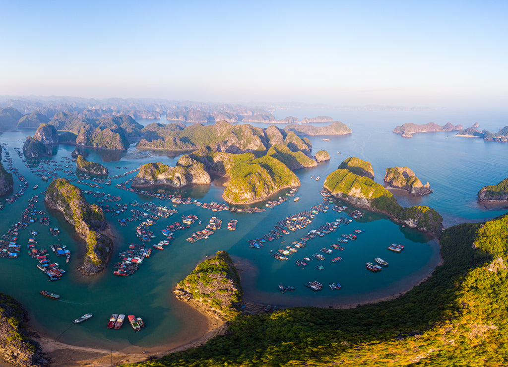 Aerial sunset view of Lan Ha bay and Cat Ba island, Vietnam, unique limestone rock islands and karst formation peaks in the sea, floating fishermen villages and fish farms