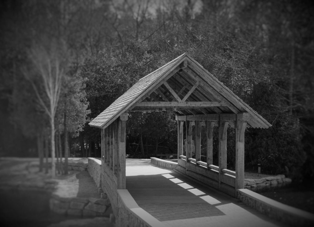 A beautiful old covered wooden bridge in alpena Michigan in black white