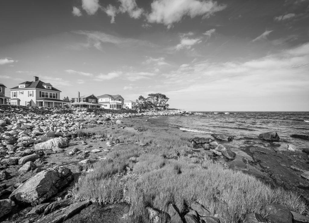 Rocky coast and beachfront homes at Concord Point, in Rye, New Hampshire in black white