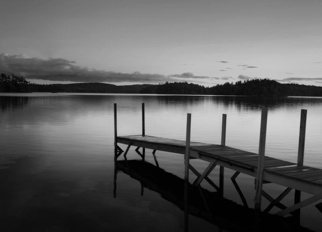 Old pier in a lake at the sunset in Maine in black white