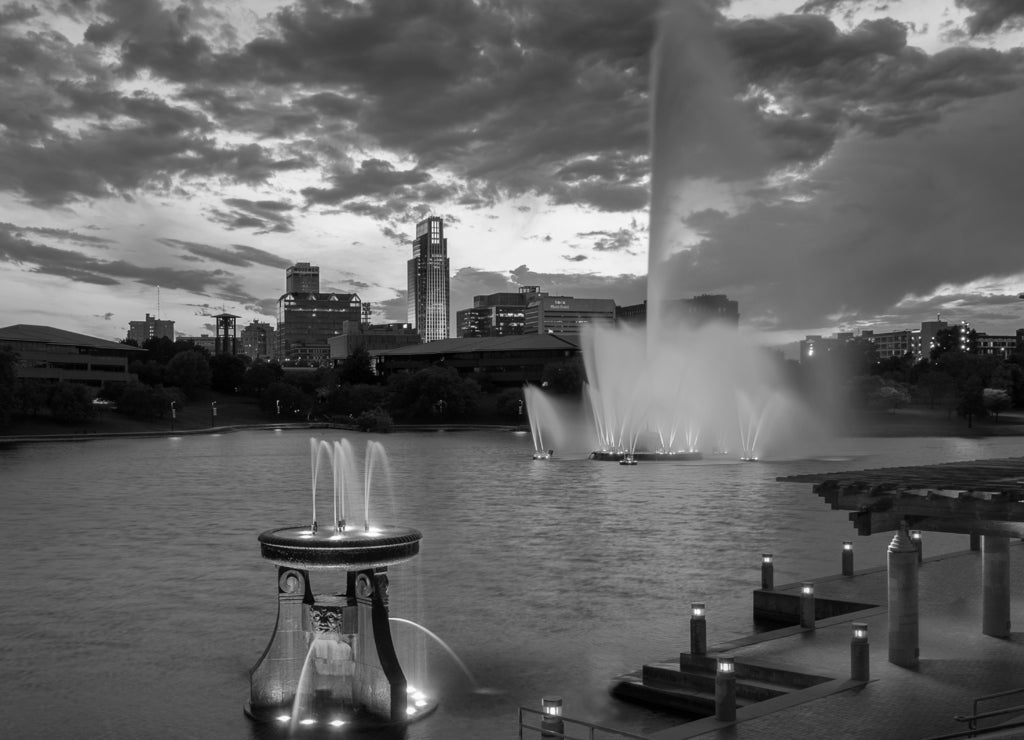 Colorful water fountains in front of downtown at Heartland of America Park in Omaha Nebraska in black white