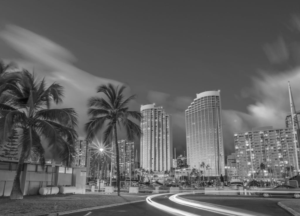 Luxurious hotels overlooking the Ala Wai Harbor at twilight and the light trails in Honolulu, Oahu, Hawaii in black white