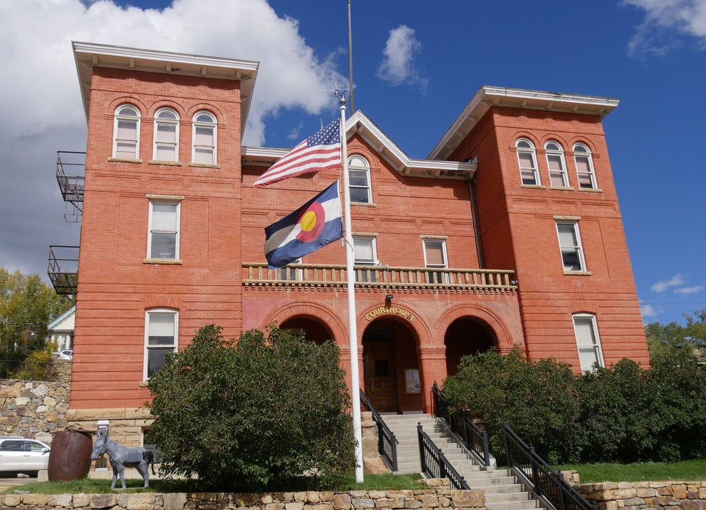 Front view of the Gilpin County Courthouse at Central City in Colorado, with the American and state flags in front