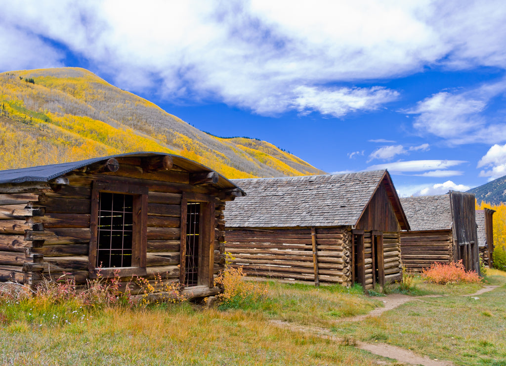 Ashcroft Main Street - Well preserved log structures along main street in historic Ghost Town of Ashcroft, Colorado in Pitkin County in Autumn with Golden Aspen covered hilltop in background