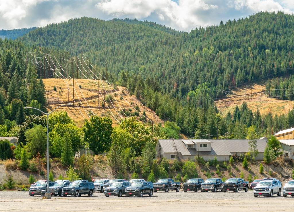 Rows of new cars underneath the mountain ski resort of Silver Mt. in the city of Kellogg Idaho, USA, a Superfund site due to ground contamination
