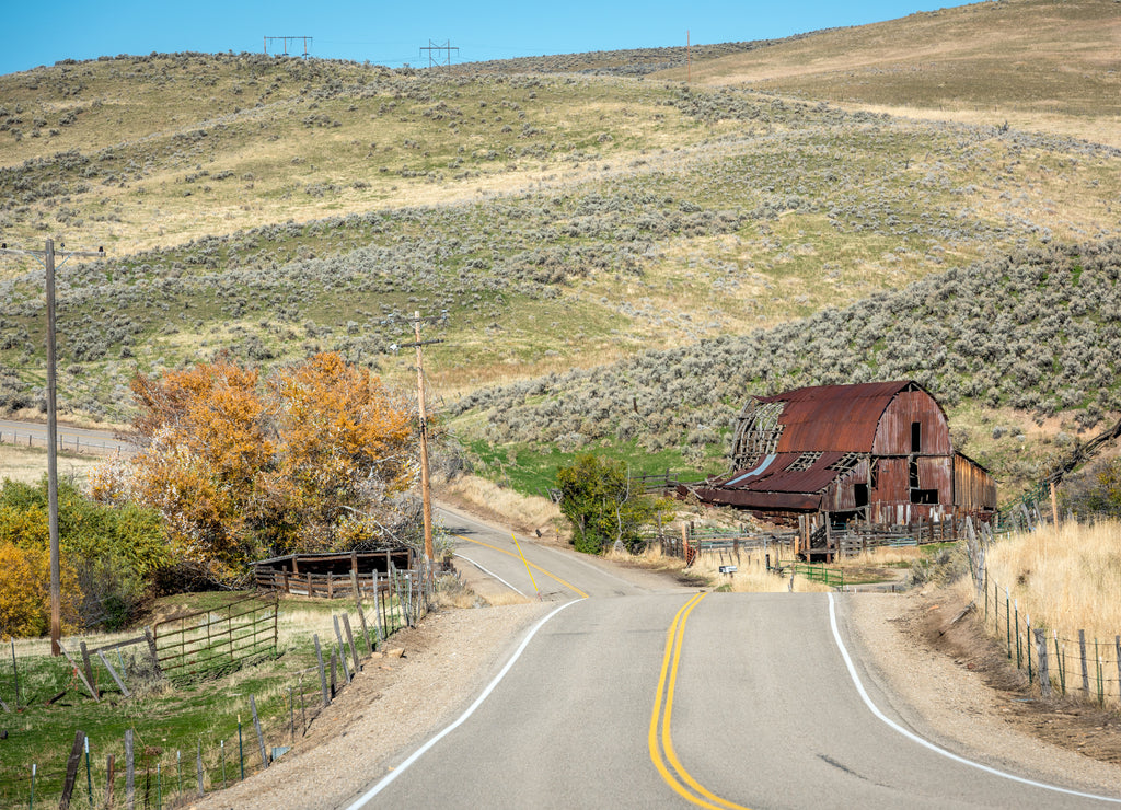 Iconic barn in Idaho with fall trees and country road