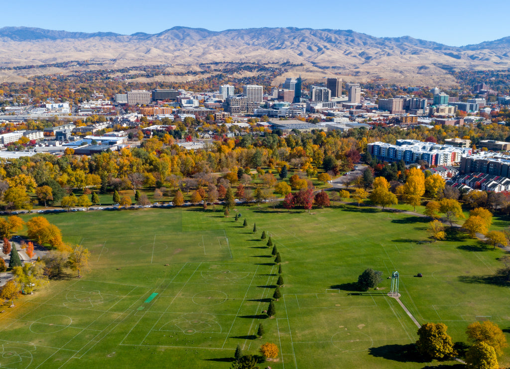 City park with trees in autumn along with the skyline of Boise, Idaho