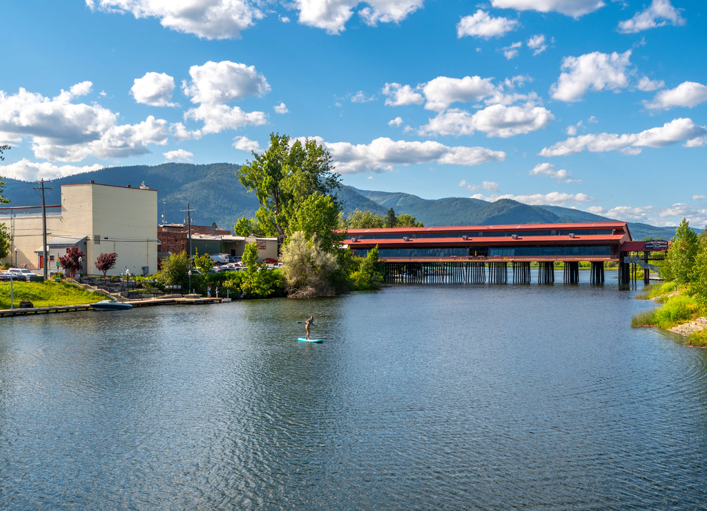 A young female paddleboarder on Sand Creek, a small river canal off Lake Pend Oreille in the town of Sandpoint, Idaho