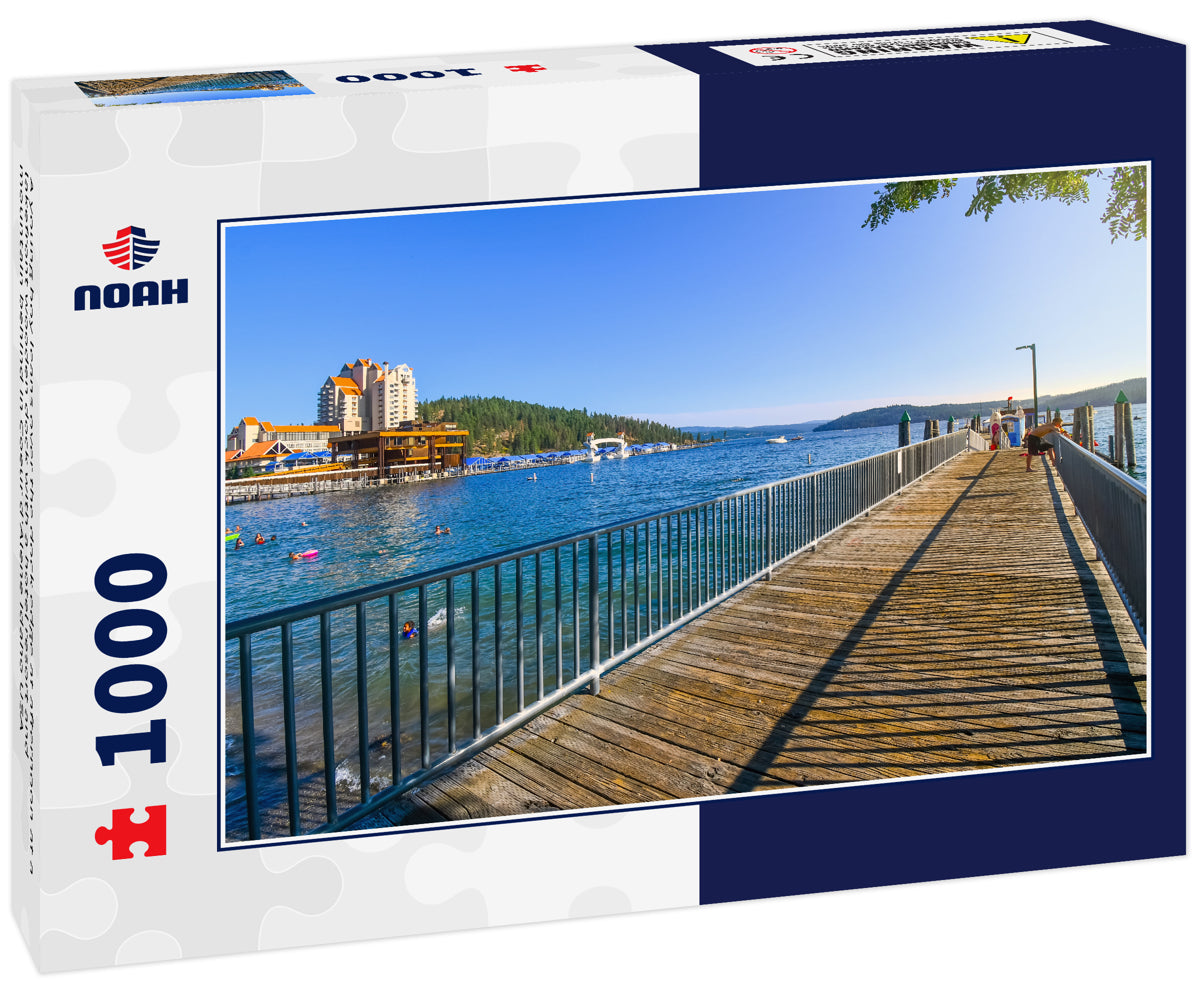 A young boy leans over the dock edge at afternoon at a lakefront wooden dock with a hotel resort and mountain behind in Coeur d'Alene Idaho USA