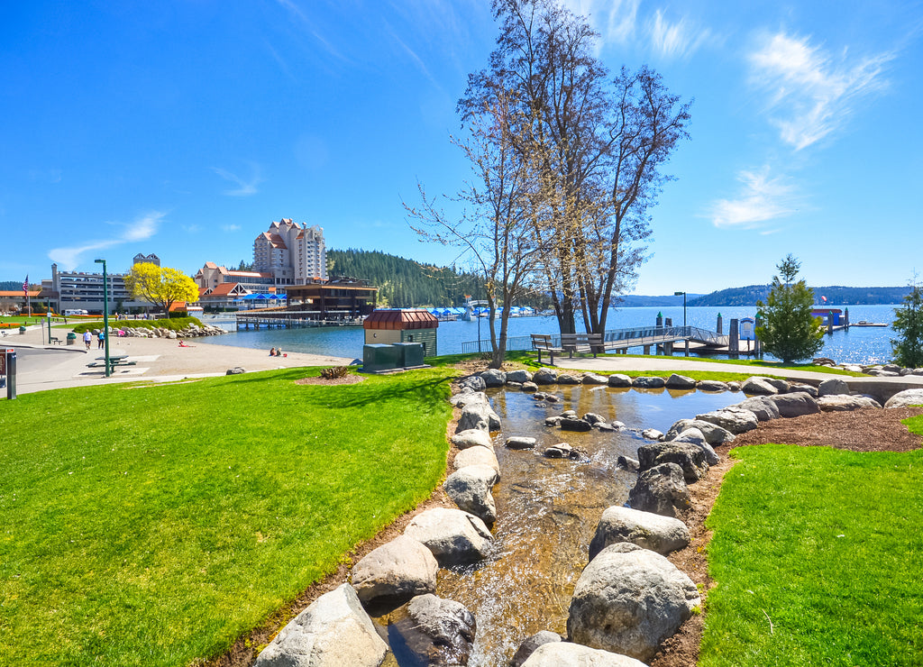 A small stream flows into the lake with the downtown and Tubbs Hill in view in Coeur d'Alene, Idaho, USA