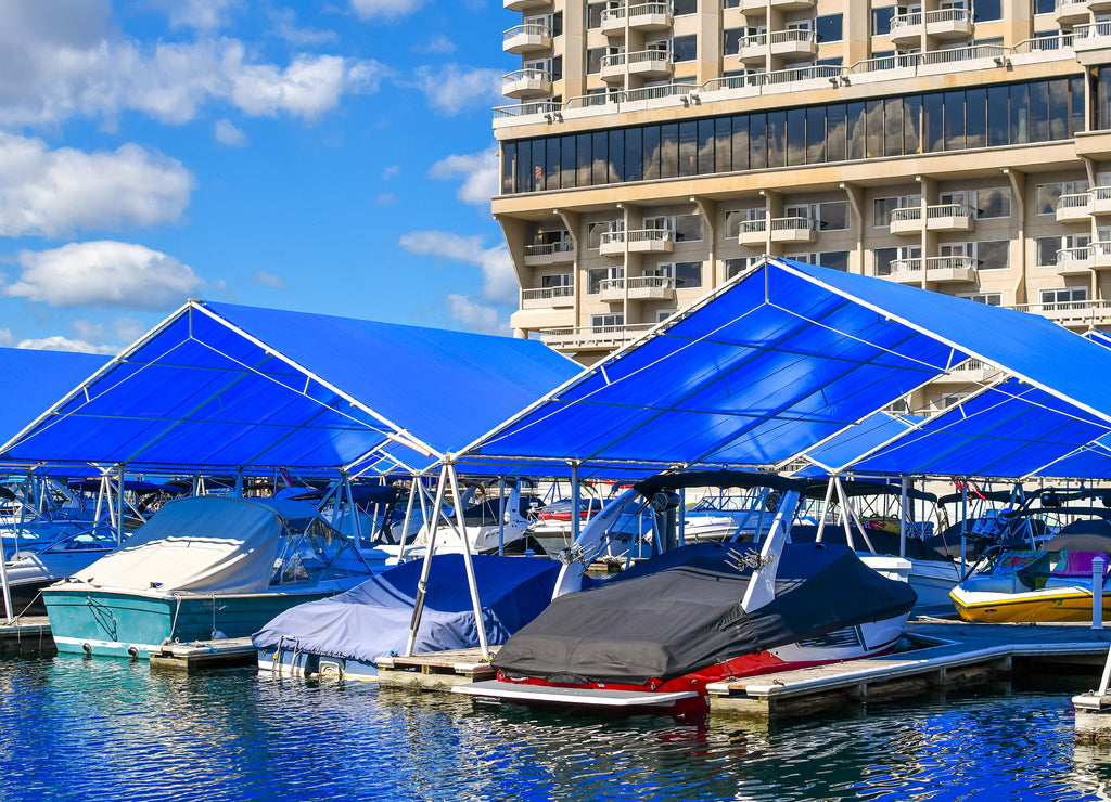 Boats in their covered slips in the marina and boardwalk of a downtown lakefront resort in the Inland Northwest town of Coeur d'Alene, Idaho, USA