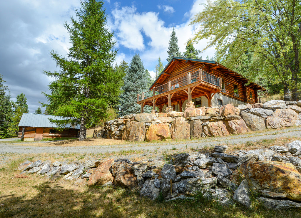 A rustic log cabin and detached shop or garage in the rural mountains of Coeur d'Alene, Idaho, USA