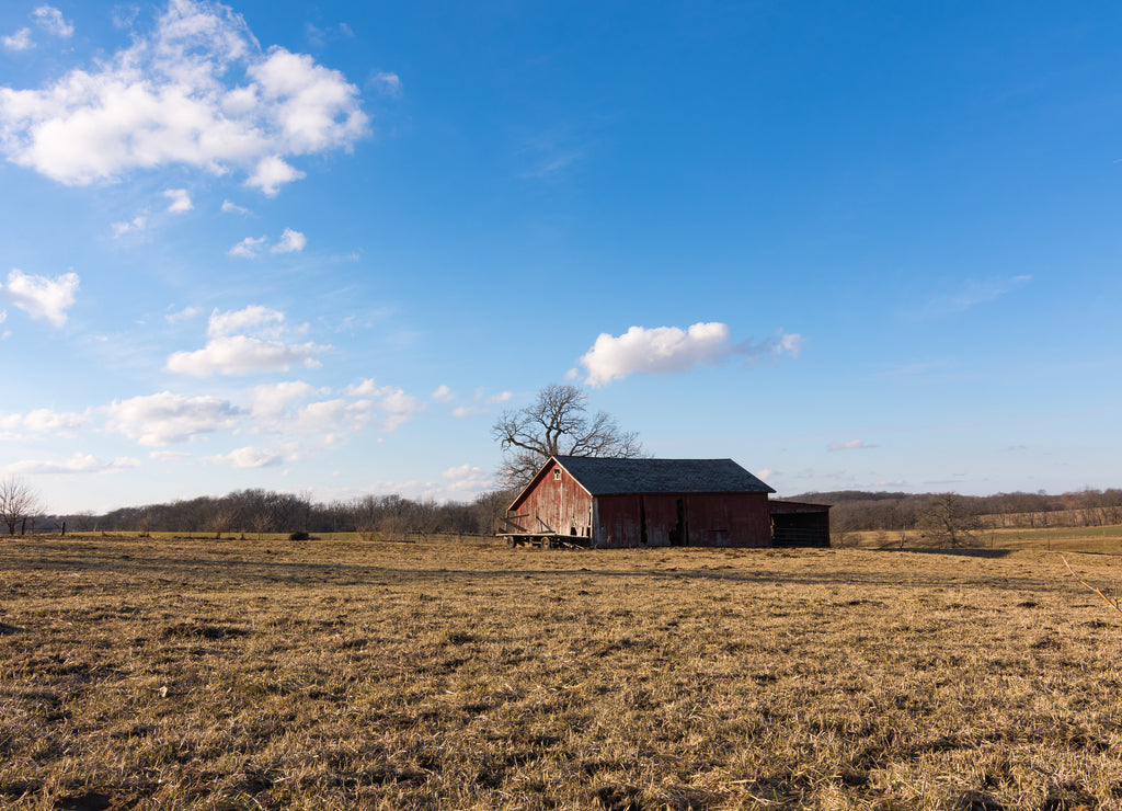 Old red barn in the open field. Putnam County, Illinois, USA