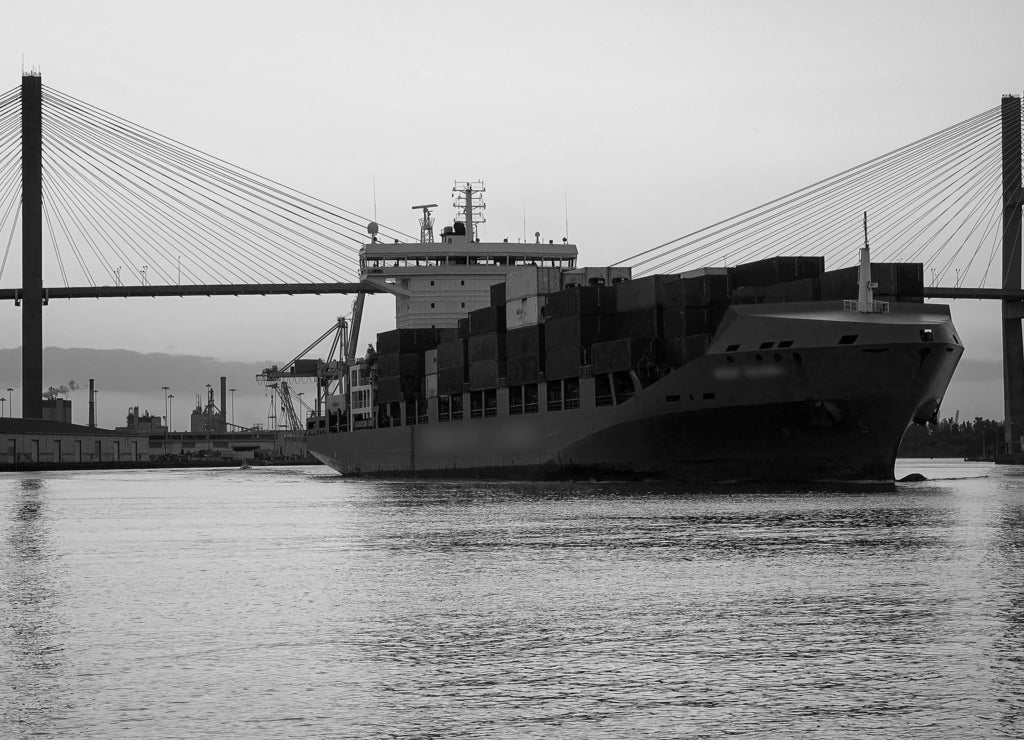 Commercial cargo ship as it leaves the Port of Savannah in Georgia in black white