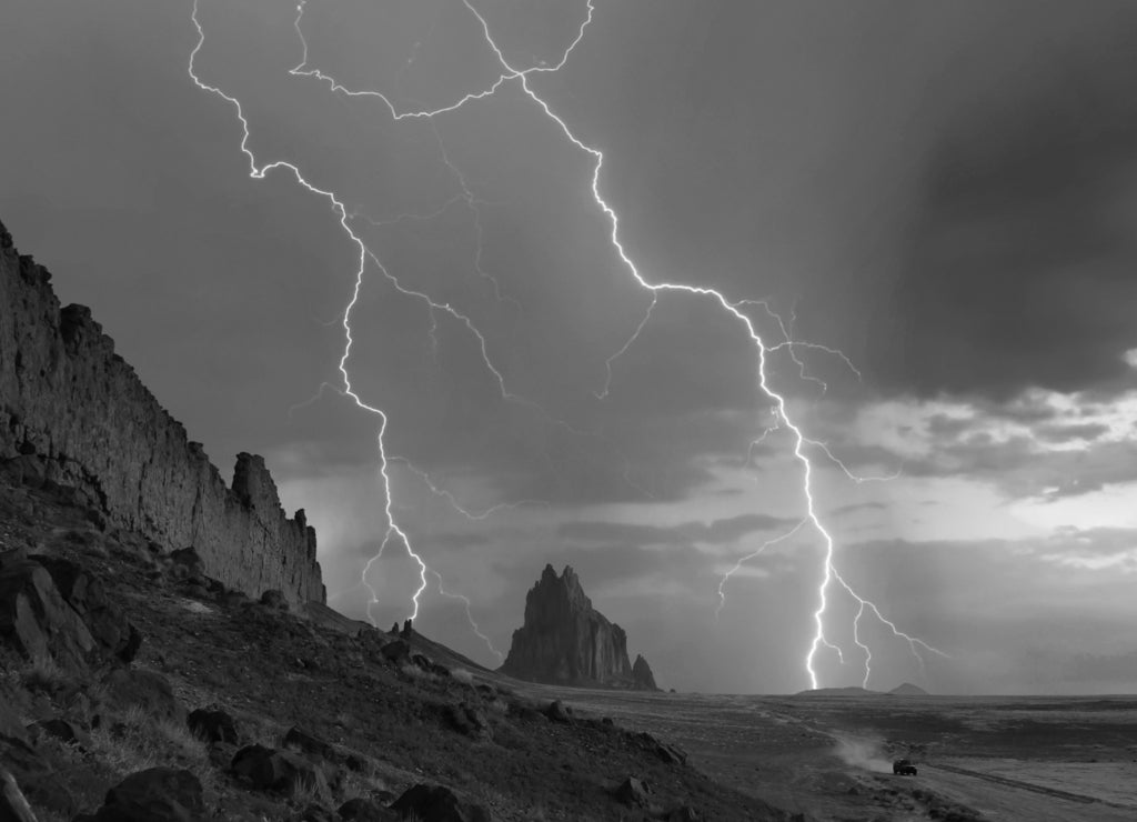 An SUV Races Away from a Thunderstorm at Shiprock, New Mexico in black white