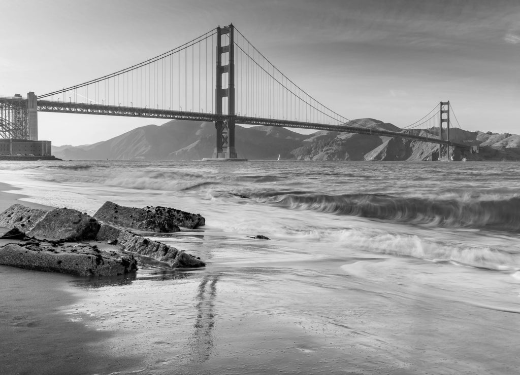 Sunset at the beach by the Golden Gate Bridge in San Francisco California in black white