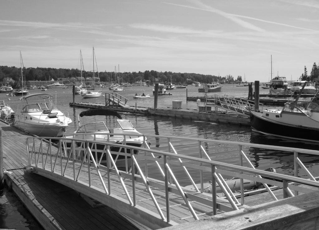 View over the water at Boothbay Harbor in Maine with boats and buoys in black white