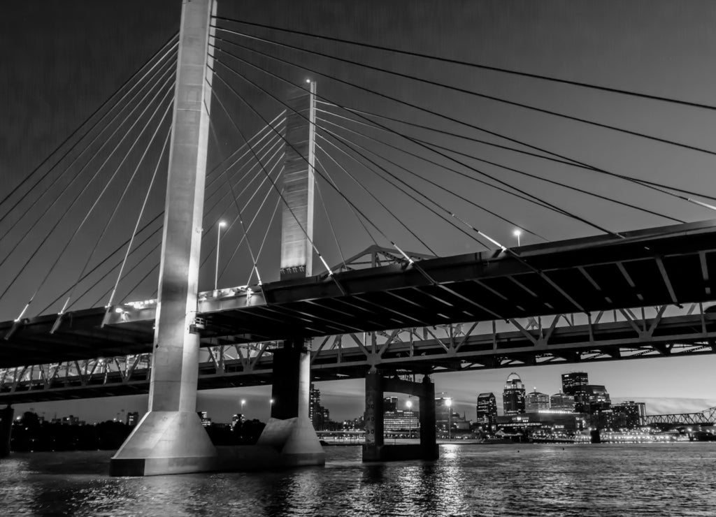 Louisville, Kentucky, USA downtown skyline from under the Abraham Lincoln bridge on the Ohio River at dusk in black white