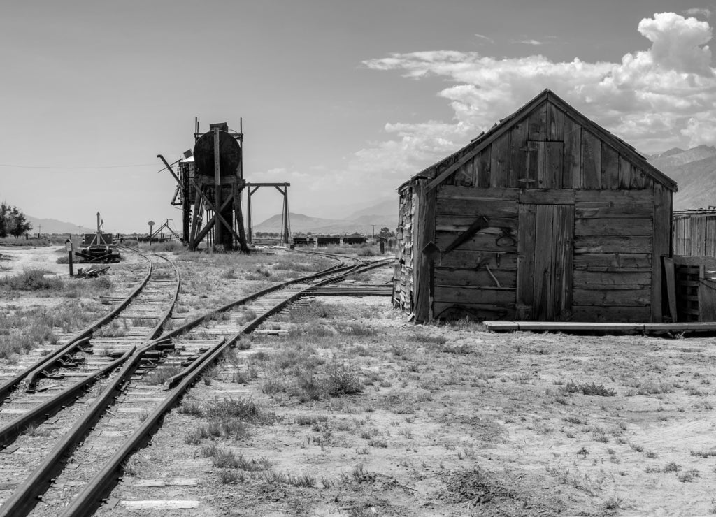 Old abandoned oil well and storage sheds, part of the former Laws Railroad in Inyo County California in black white