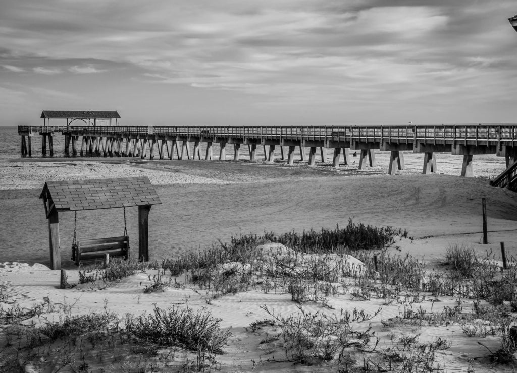 Tybee Island pier in Southern Georgia United States on the beach of the Atlantic Ocean, and a swing in black white