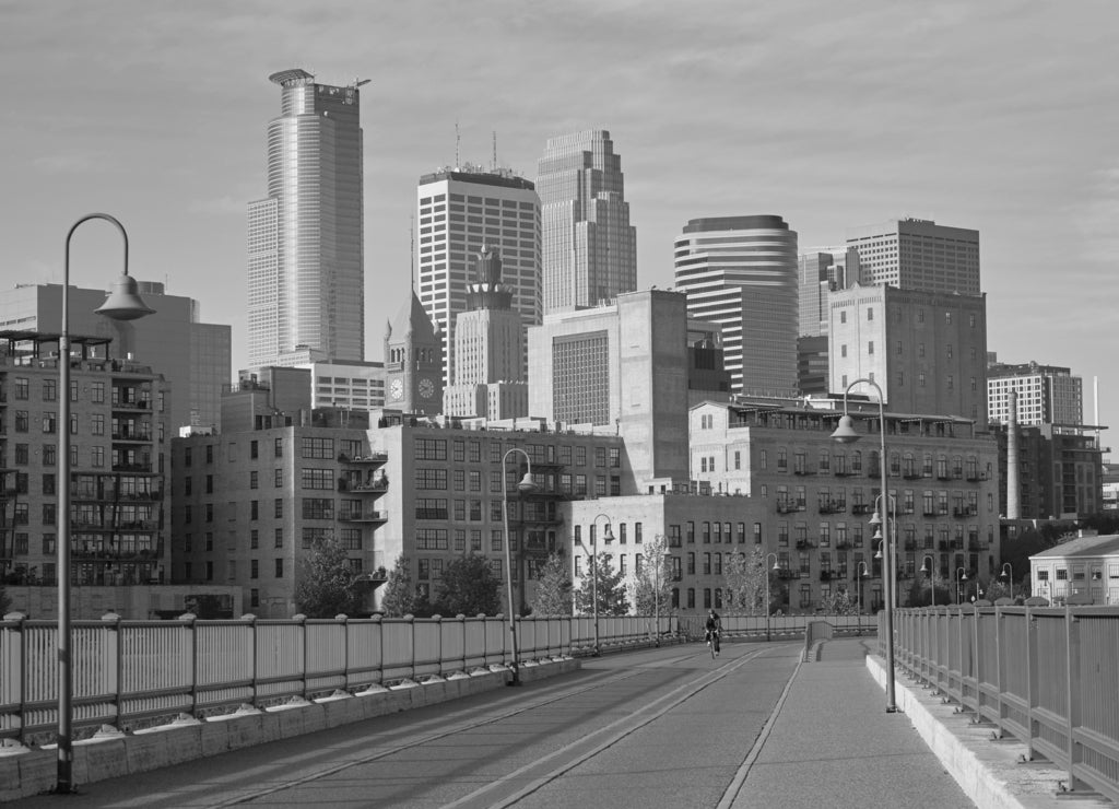 Stone Arch Bridge with downtown Minneapolis Minnesota skyline in the background in black white
