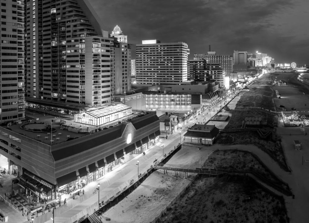 Aerial panorama of Atlantic city along the boardwalk at dusk. In the 1980s, Atlantic City achieved nationwide attention as a gambling resort and currently has nine large casinos, New Jersey in black white