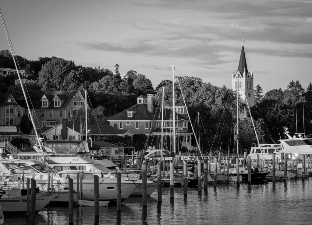 The Marina at Mackinac Island with Saint Anne's church and the historic Victorian houses a sunset shot from Lake Michigan in black white