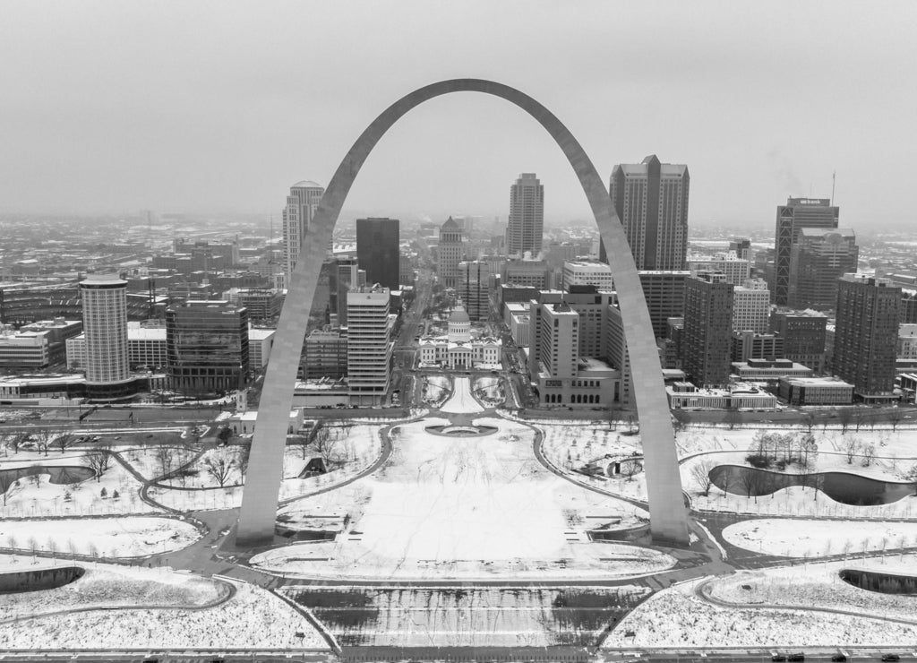 St Louis, Missouri \ USA: Aerial view of a downtown covered in snow behind Gateway Arch. Old courthouse, The Basilica Of Saint Louis, and a Busch stadium on a winter day in black white