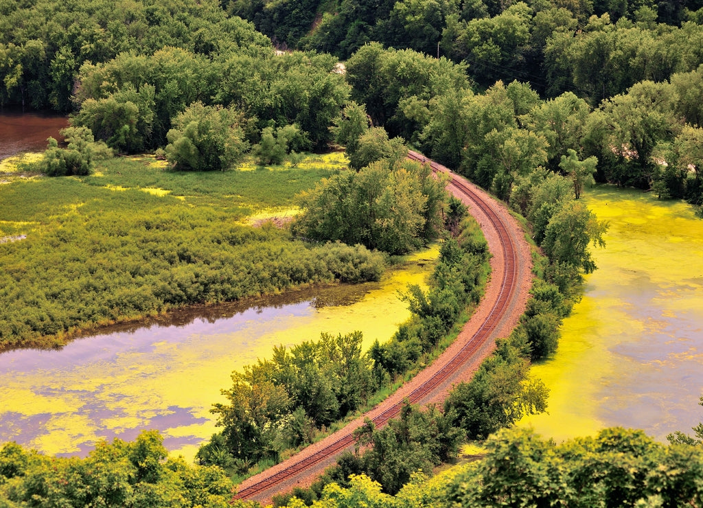 A single track railroad branch line curves in its journey along the banks of the Mississippi River near Harpers Ferry, Iowa USA