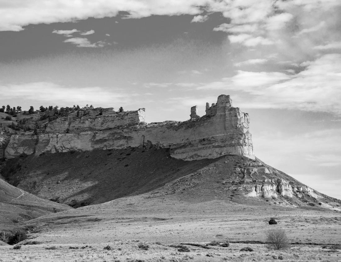 Noah Jigsaw Puzzle Sunrise on a Rocky Mesa in the New Mexico landscape with small puffy clouds in the blue sky in black white 1000 pieces