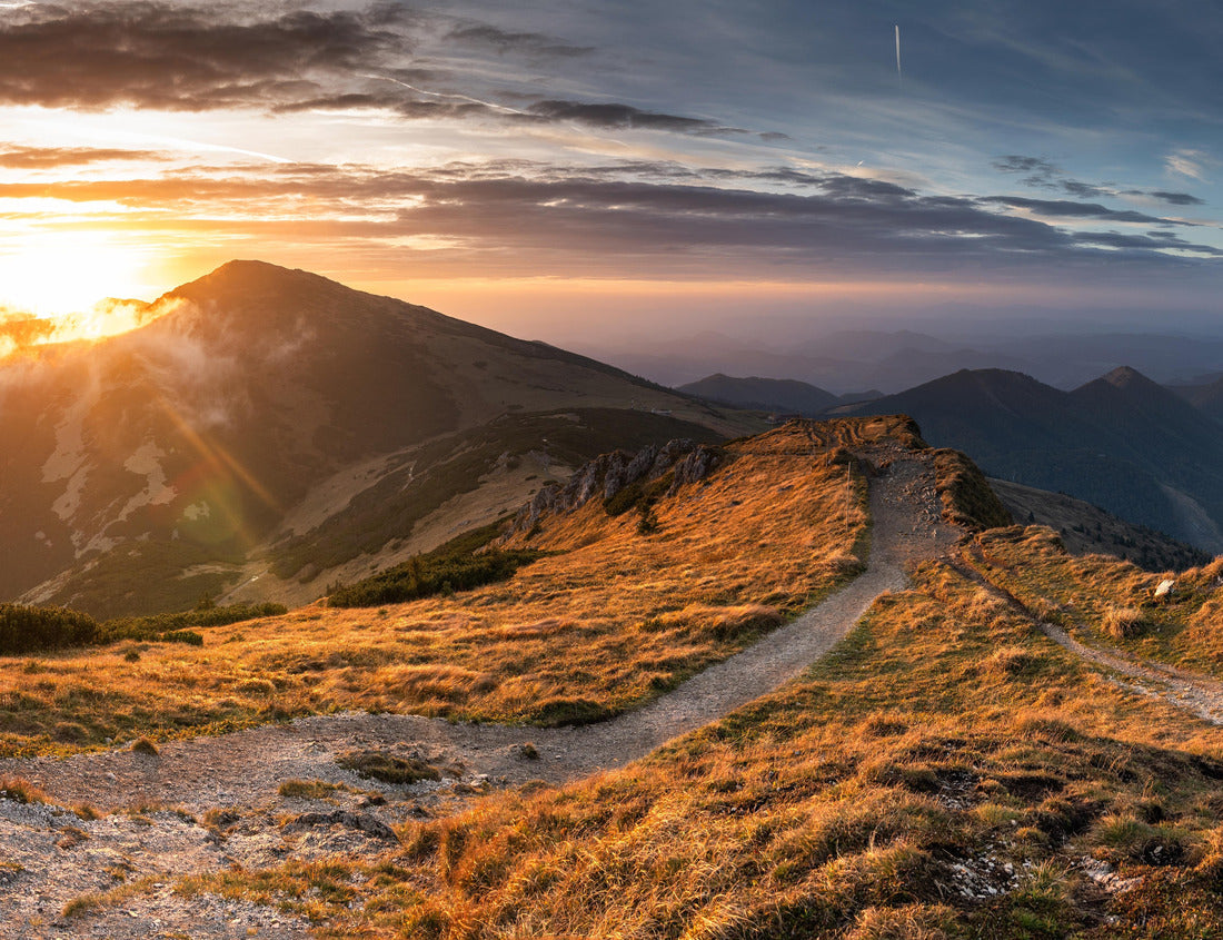 Noah Jigsaw Puzzle Beautiful sunset on mountain with trail leading up side. Trail is surrounded by grass and rocks. Sun is setting behind mountain, casting warm glow on 1000 pieces