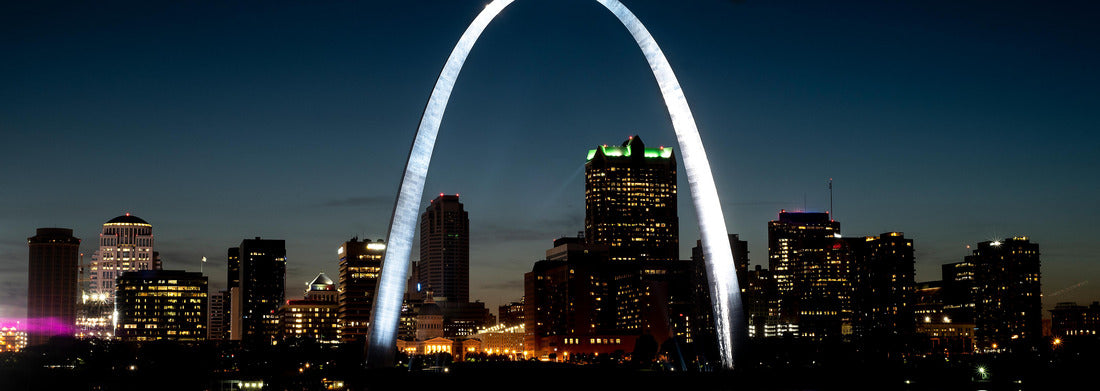 St. Louis gateway arch reflecting shining light at night on Mississippi River in foreground, tall office buildings and skyline in background 1000pc Panoramic Puzzle