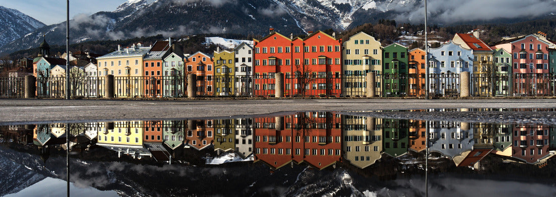 Water reflection of the distinctive colored house fronts of the Mariahilf district and Nordkette of Innsbruck, Austria captured from Marktplatz. This is the famous view of Innsbrucks cityscape 1000pc Panoramic Puzzle