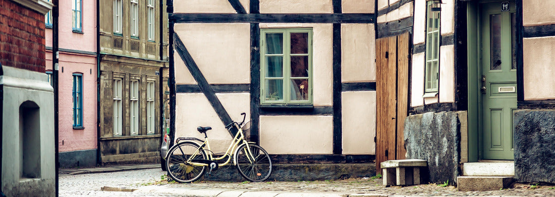 Yellow bicycle near building facade with a window, Scandinavian style. Street in Lund, Sweden 1000pc Panoramic Puzzle