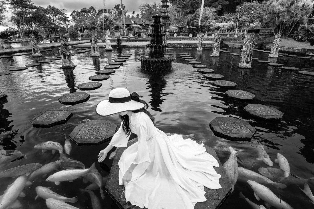 Woman feeding colorful fish in pond at Tirta Gangga Water Palace in Bali, Indonesia 2000pc PuzzleBlack and White