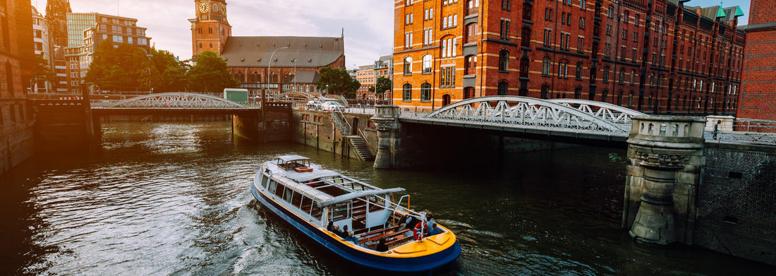 Noah Jigsaw Puzzle Touristic cruise boat on a channel with bridges in the old warehouse district Speicherstadt in Hamburg in golden hour sunset light, Germany panorama 1000 pieces