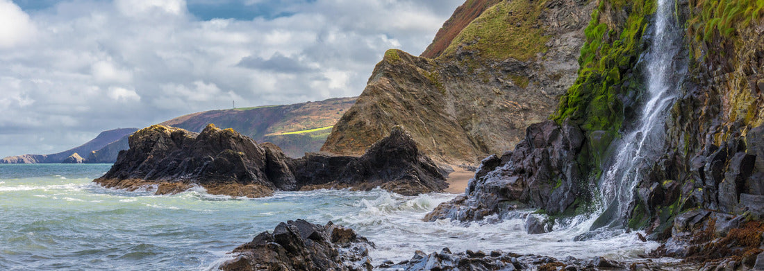 Noah Jigsaw PuzzleA waterfall on the Welsh coast in the small fishing village of Tresaith. The sea is wild, as is the white-blue cloudy sky. In the background the high cliffs, Panorama 1000 Pieces