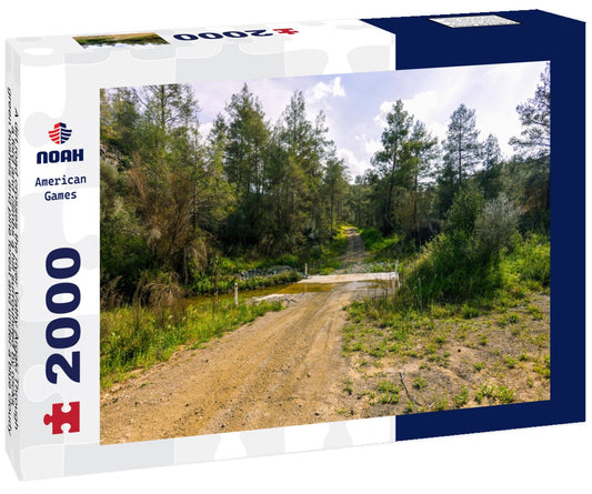 Noah Jigsaw Puzzle A dirt road crosses the river Vathy Argaki Through a ford and climbs a hill surrounded by rocks, green bushes and pine forest and under a blue cloudy sky (Kornos, Larnaca District, Cyprus) 2000 pieces