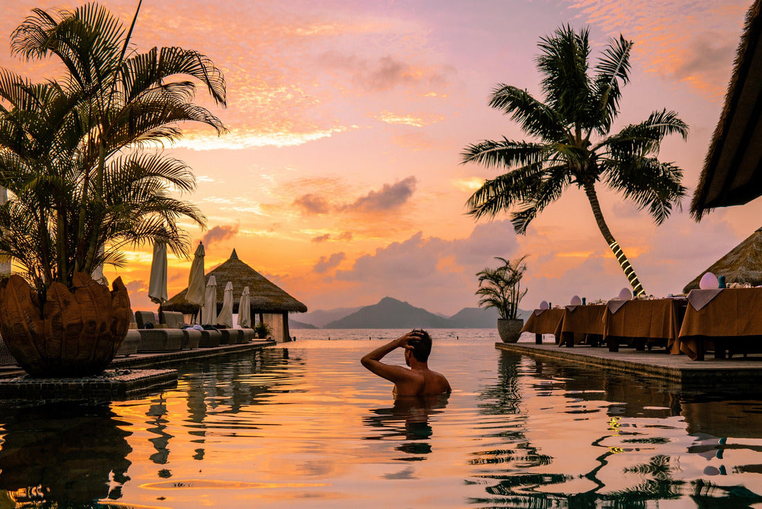 Luxury swimming pool in tropical resort, relaxing holidays in Seychelles islands. La Digue, Young man during sunset by swimpool Seychelles 2000pc Puzzle