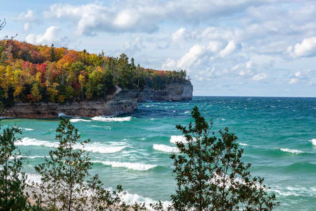 A forest on the Upper Peninsula creates an autumn backdrop at Chapel Beach in northern Michigan. Lake Superior crashes onto the beach, puffing clouds of white across the blue sky 2000pc Puzzle