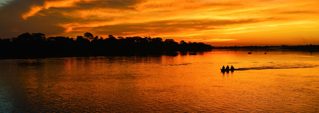 The silhouette of a small motorized canoe on the Guaporé River - Itenez at sunset, village of Ricardo Franco, Indigenous Land Vale do Guaporé, Rondonia, Brazil, on the border with Bolivia 1000pc Panoramic Puzzle