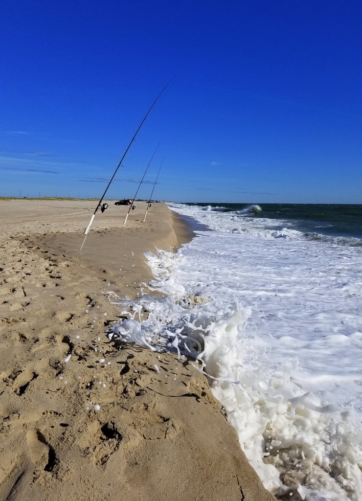 Surf fishing rods by waves near Dewey Beach, Delaware, U.S