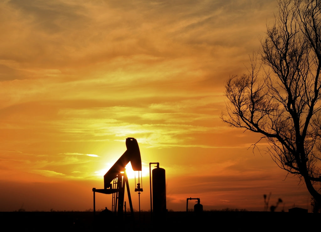 Silhouette of an Oilwell Pump with a colorful Sunset in Kansas