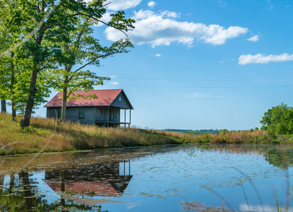 Rural old house barn reflected on pond water, panoramic view in northwest Arkansas, Ozark mountains, beautiful scenic view