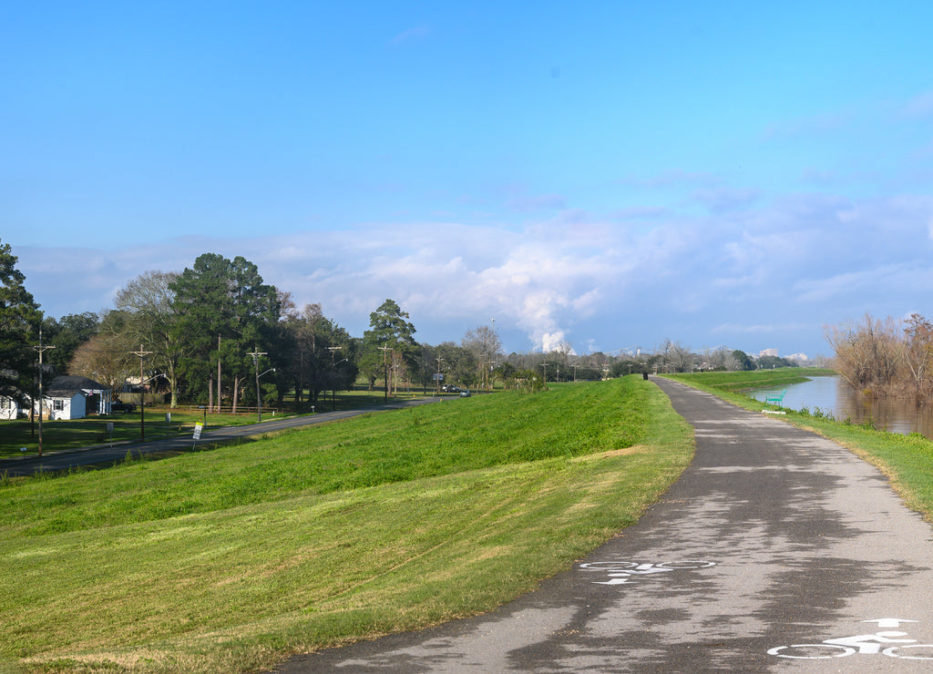Paved bike path on top of earthen dike levee along Mississippi River in Louisiana