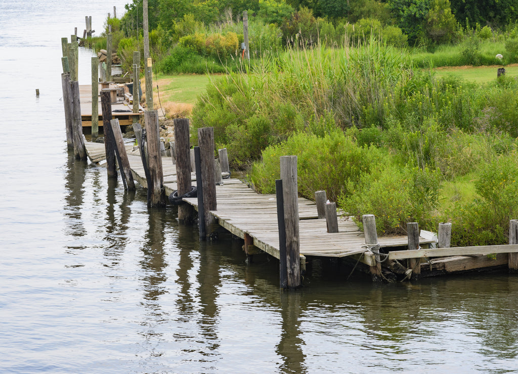 Dilapidated pier alongside land on Lake St. Catherine in Louisiana